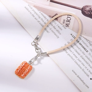 Detail of creative bread slice charm on beige woven rope with silver lobster clasp