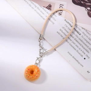 Detail of creative donut pendant with colorful sprinkles and beige braided rope