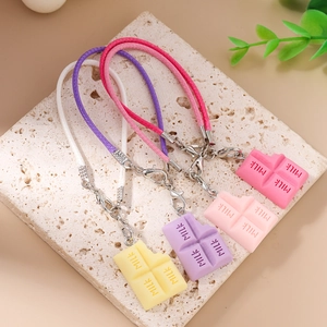 Vue détaillée de breloques de téléphone en résine chocolat en jaune, violet et rose