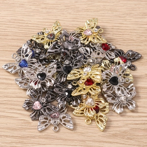 Makroaufnahme von Schmetterling-Metallanhängern mit bunten Herz-Strasssteinen für DIY-Schmuck