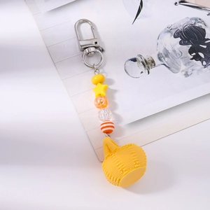 Detail of yellow beaded keychain featuring a textured sphere and a silver lobster clasp