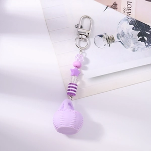 Detail of light purple beaded keychain with a miniature woven basket and star charm