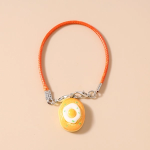 Detailed close-up of a realistic fried egg toast charm on a bright orange woven phone strap