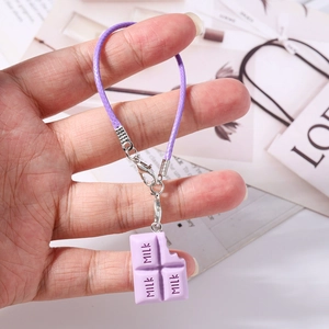 Vue détaillée du pendentif chocolat violet en silicone avec texte MILK et mousqueton