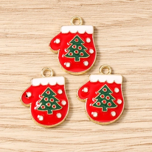 Close-up of red enamel Christmas glove pendants with green tree design for DIY jewelry