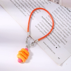 Close-up of bright orange woven lanyard with colorful spiral charm and silver metal clasp