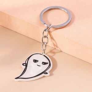 Close-up of cute white acrylic ghost keychain with pearlescent texture and silver ring