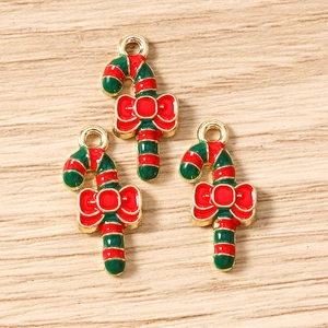 Macro shot of colorful enamel Christmas candy cane pendants with red bow for DIY jewelry making