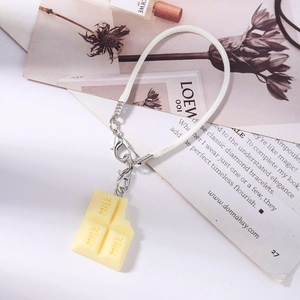 Détail d'un pendentif créatif en résine en forme de chocolat avec gravure MILK et cordon