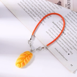 Detail of a realistic bread pendant with orange braided cord and silver metal clasp