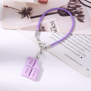 Détail du pendentif chocolat violet avec gravure MILK et cordon de téléphone tressé