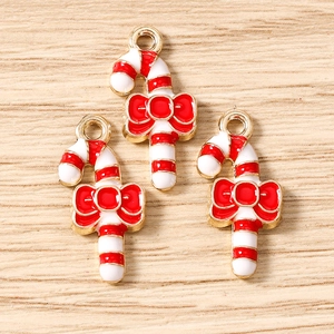 Detail of red and white striped Christmas cane charms with bow and gold metal plating