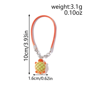 Detail of a turtle bag charm with an orange woven strap and silver lobster clasp