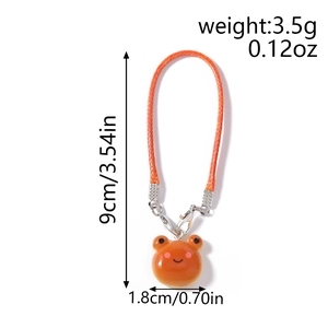 Detail showing dimensions of the orange frog charm with a braided strap and size marks