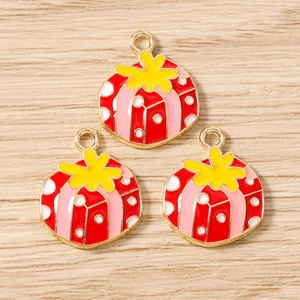 Detailed macro of colorful enamel Christmas gift box charms with golden alloy metal finish