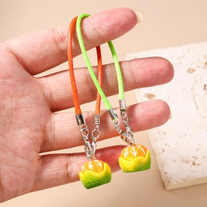 Close-up of orange and green citrus fruit charms with lobster clasp and braided lanyard