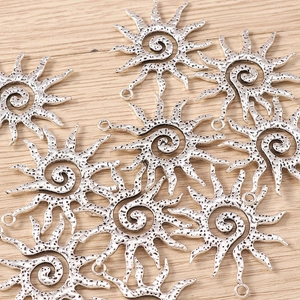 Macro shot of silver sun spiral pendants with vintage texture for DIY jewelry making