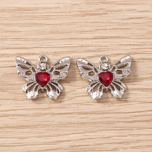 Detailansicht der Schmetterlingsanhänger mit roten Herzsteinen für DIY-Schmuck