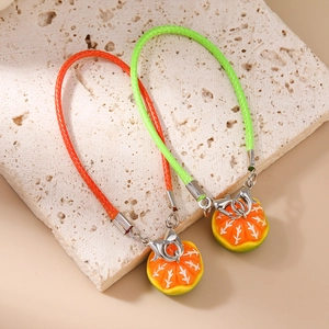 Detailed macro view of woven leather fruit charms with realistic orange slice resin pendants