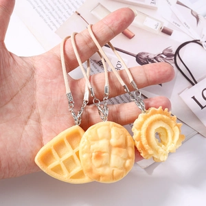 Three realistic simulation food charms including waffle and croissant with braided lanyards