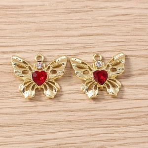 Makroaufnahme vergoldeter Schmetterlingsanhänger mit rotem Herzkristall und Strass-Detail