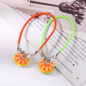 Detail of realistic orange slice charms on woven phone straps with silver lobster clasps