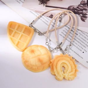 Detail of waffle and cookie pendants with woven lanyards on a lifestyle magazine