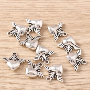 Detailed view of silver heart wing pendants with textured feathers for DIY jewelry making