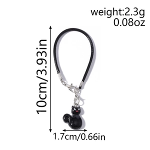 Macro shot of a black cat phone charm with woven lanyard and size dimensions