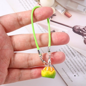 Detailed macro view of an orange fruit pendant with green rope and metal lobster clasp