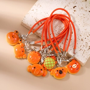 Detailed view of orange animal bag charms featuring resin koala and turtle shapes