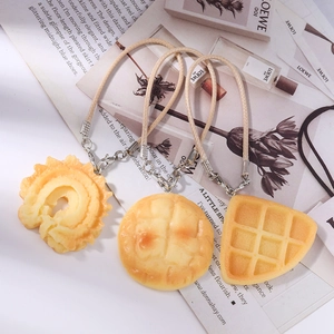 Realistic waffle and donut food pendants with woven lanyards on a stylish background