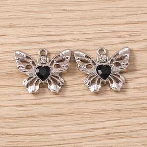 Detailansicht der silbernen Schmetterlingsanhänger mit schwarzen Herzsteinen für Schmuck