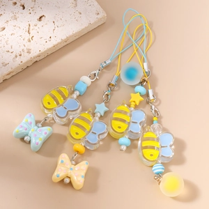 Cartoon bee and butterfly phone charms with colorful beads and stars on plain background