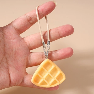 Detail showing miniature waffle pendant with beige woven lanyard and metal ring