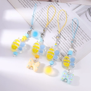 Detail of colorful beaded phone charms featuring acrylic bees, bows, and star beads
