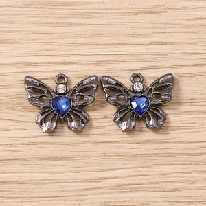 Detailansicht der dunklen Schmetterlingsanhänger mit blauem Herz-Kristall und Zirkon-Steinen