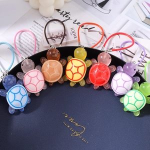 Colorful resin turtle charms in seven vibrant colors arranged in a stylish fan layout