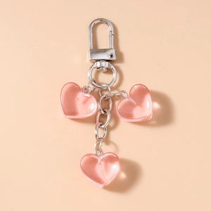 Dettaglio di un portachiavi a tre cuori rosa in resina con catena in metallo argento