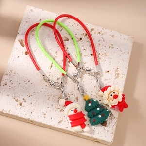 Detailed view of Christmas snowman, tree, and Santa charms with woven red and green straps