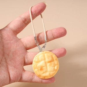 Detailed close-up of a realistic waffle pendant with textured surface and beige braided cord