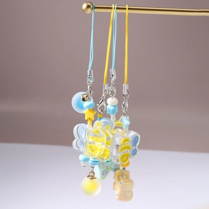 Detail of colorful cartoon animal pendants with woven cords for bags and phones