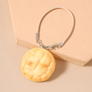 Macro detail of a realistic pineapple bun charm with textures on a beige display stand