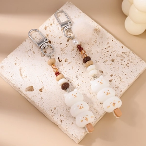 Détails d'un porte-clés à perles avec figurines en résine et pompons doux pour sacs