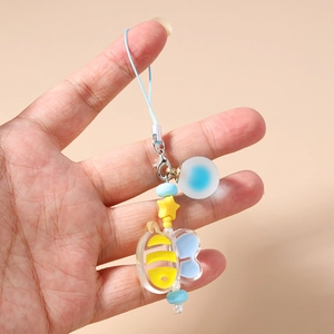 Close-up of a cartoon bee acrylic charm with yellow star bead and blue lanyard strap