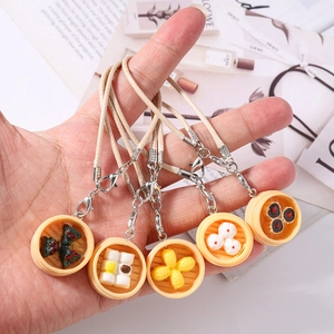 Miniature dim sum dumpling charms in bamboo steamers with woven leather phone straps
