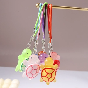 Detailed view of colorful resin sea turtle pendants with glitter and braided cords