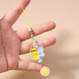 Detail of cartoon bee phone charm featuring yellow strap and transparent acrylic beads