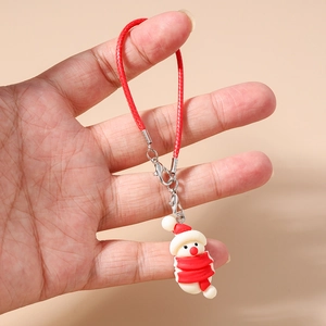 Detail view of a cute snowman phone charm with a red woven strap and metal clasp