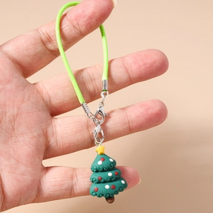 Detail view of a handmade green Christmas tree phone charm with a star and woven strap